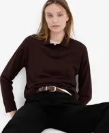 Jersey de punto bordó con cuello polo y cierre frontal de botones ocultos, de manga larga y diseño recto.