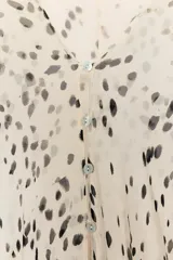 Top de Zara Woman Collection con escote en pico y mangas largas abullonadas con puños. Presenta un cierre frontal con botones y un diseño holgado con estampado de manchas.