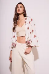 Blusa color blanco con estampado de cachemir en color rojo y bordado floral en el ruedo y mangas acampanadas.