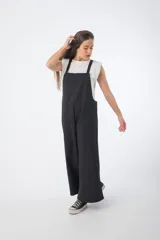 Mono negro de denim con corte oversize, breteles anchos y piernas anchas.