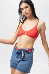 Top de bikini color coral/rojo con textura acanalada y un aro metálico en el centro del escote. Posee tirantes finos ajustables y copas removibles.