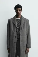 Abrigo regular fit de color gris oscuro, confeccionado en tejido con mezcla de lana de origen italiano. Cuenta con cuello con solapas de muesca, manga larga, bolsillos de vivo en la cadera, bolsillo interior, abertura en el centro de la espalda y cierre frontal de botonadura.