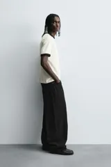 Jeans de denim de algodón color negro, con corte balloon fit relajado desde la cadera y ligeramente estrechado en el bajo. Tiro medio, cinco bolsillos y cierre frontal con cremallera y botón.