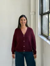 Saco tipo cardigan de punto, color bordó, con escote en V y cierre frontal de botones. Presenta mangas largas con puños acanalados y un diseño de calce holgado.