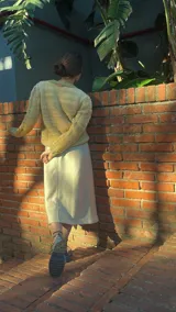 Cárdigan color verde claro tejido a mano con trenzas y distintas texturas, con botones de madera de olivo.