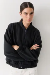 Campera bomber de paño color beige, con cierre frontal, cuello alto y puños elásticos.