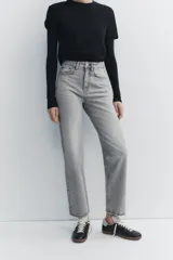 Jeans de tiro alto color negro con efecto lavado, corte mom fit, cinco bolsillos y cierre frontal con cremallera y botón metálico.