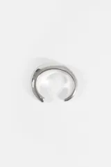 Pulsera tipo cuff de diseño minimalista y voluminoso con acabado metálico brillante.