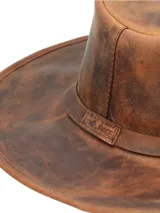 Sombrero de ala ancha confeccionado artesanalmente en cuero genuino con acabado desgastado. Presenta una banda interior para control de sudor y ojales metálicos laterales para ventilación.