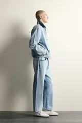 Cazadora de denim de algodón con efecto lavado, corte cropped, cuello solapa, cierre frontal con cremallera de doble dirección, manga larga con puños abotonados y bolsillos laterales.