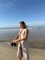 Vestido midi sin mangas color beige, con corte recto y detalle de franja vertical marrón en el centro.