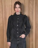 Camisa de denim color negro con efecto acid wash, con cuello mao con volados, botonadura frontal y detalles de volados en los hombros y puños elásticos.