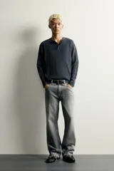 Camiseta relaxed fit de punto negro tejido en hilatura de algodón, con cuello redondo, cierre frontal de botonadura y manga larga con acabado en rib.