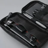 Riñonera negra con correa ajustable para usar como bandolera. Fabricada con material xPac X21 impermeable, cuenta con apertura de 180°, 7 bolsillos internos, 2 bolsillos externos, detalles en color ladrillo y cierres impermeables.