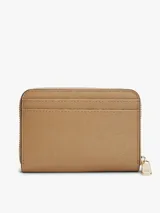 Billetera Tommy Hilfiger de tamaño compacto, color beige con acabado texturizado y cierre de cremallera perimetral con tirador metálico. Cuenta con el logo de la marca en relieve en la parte delantera.