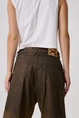 Jean baggy de tiro medio con efecto desgastado y acabado degradé en tonos tierra. Silueta amplia y recta en denim tratado a mano.