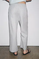 Pantalón jogger de la colección Zara Woman, color gris claro, confeccionado en hilatura con algodón y lyocell. Presenta tiro medio, cintura elástica ajustable con cordones, bolsillos laterales ocultos en costura y pierna ancha.