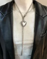 Collar doble de cadena plateada con dije de corazón con pinches.