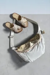 Bandolera grande de cuero blanco con detalles en cuero dorado con textura símil serpiente, cierre frontal con detalles pintados a mano y correa ajustable.