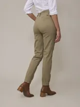 Pantalón color beige de corte recto, con pinzas en la cintura, bolsillos laterales y tobillos ajustados.