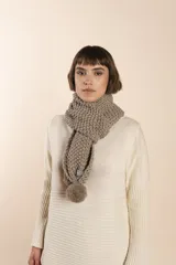 Bufanda tejida a mano en punto arroz color crudo, con detalle de pompón en uno de los extremos.