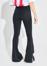 Calza negra de lycra gruesa, tiro alto, corte oxford con tajo en los laterales externos y cintura ancha.