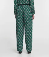 Pantalón largo de crepé con estampado de cadenas en tonos verde, blanco y negro. Tiene cintura elástica con lazo ajustable.