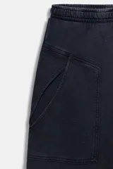 Pantalón de algodón negro con tiro medio, cintura elástica, pierna recta y grandes bolsillos laterales aplicados.