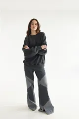 Buzo unisex oversize de felpa color gris oscuro con efecto acid wash, cuello redondo, mangas largas y detalles de costuras pespunteadas a la vista.