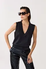 Chaleco tejido negro con lurex, escote en V y terminaciones de rib.