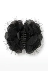 Broche para el pelo en color negro con diseño de flor de tela translúcida y bordes desmechados, con mecanismo de pinza plástica central.