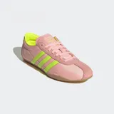 Championes Adidas modelo Tokyo de estilo retro, con exterior de nylon en color rosado y detalles en amarillo neón en las tres tiras laterales y el talón. Presenta una suela de caucho en tono marrón y un diseño de corte bajo.