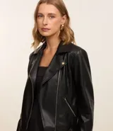 Campera biker color crema confeccionada en cuero sintético, con cuello solapa, cierre frontal con cremallera, bolsillos laterales y mangas largas con detalle de punto roma.