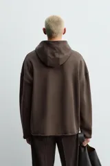 Sudadera tipo hoodie de corte relajado, confeccionada en tejido de algodón con interior de rizo. Presenta cuello con capucha, manga larga y acabados con bordes enrollados.