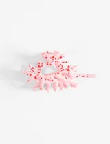 Broche con forma de caracol marino color rosa con manchas rojas.