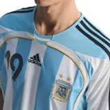 Camiseta de fútbol Adidas de la Selección Argentina, modelo Home 2006, con el número 19 en el frente. Diseño a rayas verticales celestes y blancas, con detalles en negro y dorado. Incluye logo de Adidas y escudo de la AFA.