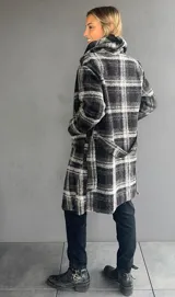 Abrigo de corte trench con estampado de tartán en tonos negro y gris. Presenta solapas amplias, bolsillos frontales y diseño abierto.