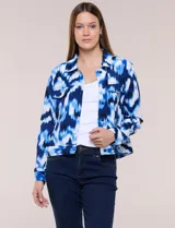 Camperita liviana de silueta entallada con estampado abstracto en tonos de azul y blanco, cuello camisero, cierre frontal con botones, bolsillos en el pecho con solapa y mangas largas.