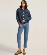 Campera de jean modelo boxy, con cuello clásico, cierre frontal mediante botones metálicos, bolsillos con solapa en el pecho y mangas largas con puños abotonados.