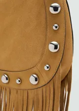 Bolso de hombro color tostado, confeccionado en piel bovina con acabado de gamuza. Presenta un diseño decorado con tachuelas metálicas plateadas en los bordes y flecos largos en la parte inferior. Incluye cierre de cremallera y forro interior de algodón.