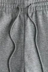 Pantalón deportivo de tiro alto confeccionado en felpa de mezcla de algodón con interior cepillado. Presenta cintura elástica con cordón de ajuste, bolsillos laterales al bies y puños elásticos en los bajos.