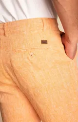 Short tipo bermuda de lino orgánico en color naranja, con cierre frontal, bolsillos laterales y traseros, y diseño de calce relajado.