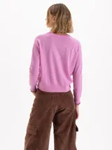 Sweater de tejido de punto en color gris, con cuello redondo, mangas largas y detalle de bordado amarillo en el puño y en el lateral inferior. Presenta un corte recto y estructura ligera.