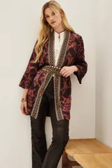 Kimono de viscosa con estampado ikat en tonos bordó y rosado, con bordes decorados con detalles geométricos y mangas tres cuartos.