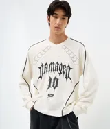 Remera de manga larga con corte boxy, cuello redondo y diseño urbano. Confeccionada en algodón, presenta recortes contrastantes en el cuerpo y mangas, junto con una estampa frontal con lettering Damaged 10.