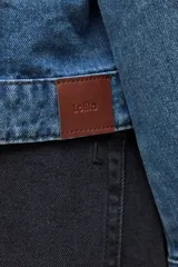 Chaqueta de jean de lavado medio, corte holgado, con cuello y puños de tela estampada a cuadros vichy en blanco y negro.