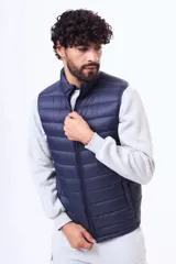 Chaleco acolchado negro con cierre frontal completo y cuello alto. Diseño ligero y sin mangas, ideal para superponer capas.