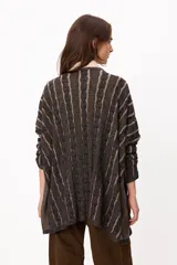 Sweater de tejido artesanal con diseño de rayas verticales en tonos camel y beige, corte holgado, cuello redondo y puños altos ajustados.