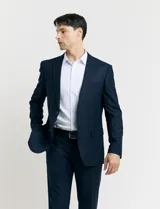 Ambo de corte clásico en color azul oscuro con sutil patrón de rayas verticales. Incluye saco de dos botones con solapas de muesca y bolsillos con solapa, junto con pantalón de vestir a juego de corte recto.