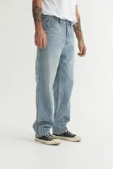 Pantalón de jean celeste de corte recto y holgado, con bolsillos laterales y traseros, y detalle de bolsillo tipo carpintero en la pierna.